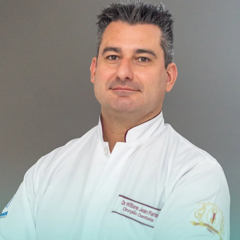 Retrato do Dr. Willians Jean Farias, fisioterapeuta, de jaleco branco e braços cruzados